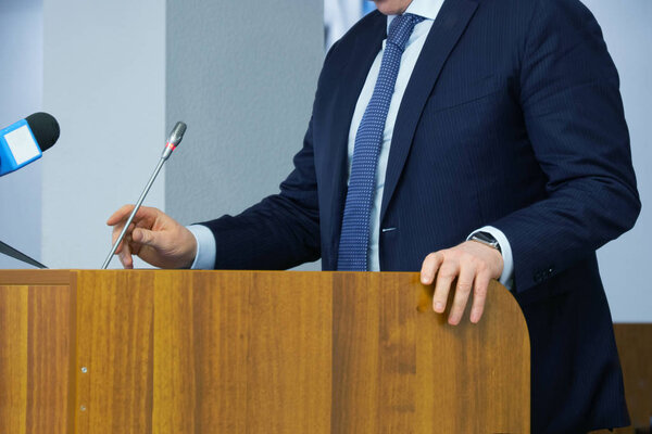 The speaker corrects the microphone during a meeting, conference
