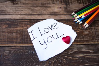  Ahşap masa, kalp, renkli kalemler bir notla ilgili kitaplar