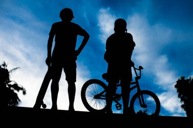 İki genç adamın arka görüntüsü bmx bisiklet ve kaykay