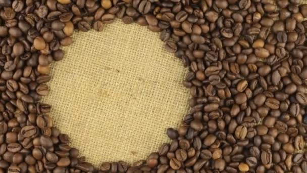 Rotación de los granos de café acostados en saco con espacio para su texto — Vídeos de Stock