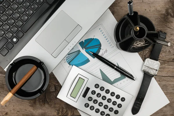 Meja pengusaha, laptop, cerutu dan diagram sebagai latar belakang — Stok Foto