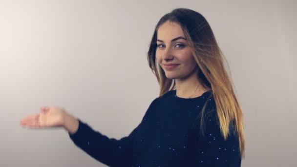 Bruna mostrando presentazione, dai capelli lunghi ragazza alla moda che tiene vuoto mano palmo copia spazio per il prodotto . — Video Stock