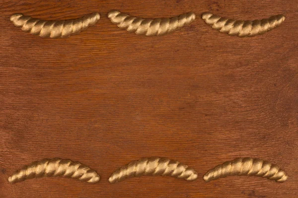 Cornice di lusso in gesso stucco dorato, sdraiato su un legno scuro — Foto Stock