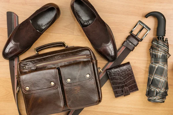 Klasik kahverengi süet ayakkabı, çanta, kemer ve ahşap zemin üzerinde şemsiye — Stok fotoğraf