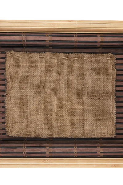 Rám z pytloviny, ležící na bambusové rohoži v podobě rukopisu — Stock fotografie
