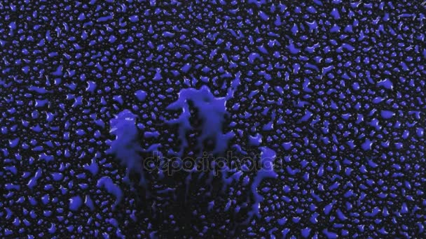 Un vent fort souffle des gouttes de peinture bleue avec une surface noire . — Video