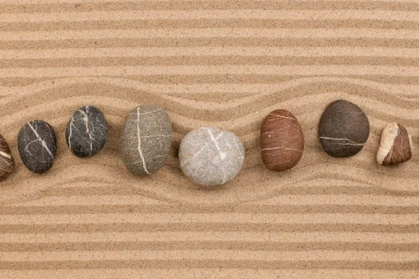 Una fila de piedras sobre la arena, con espacio para el texto . — Foto de Stock