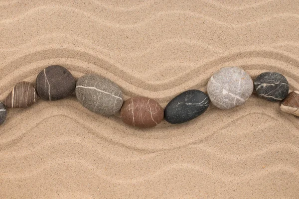 One row of stones lying on the sand, with space for text. — Stock Photo, Image