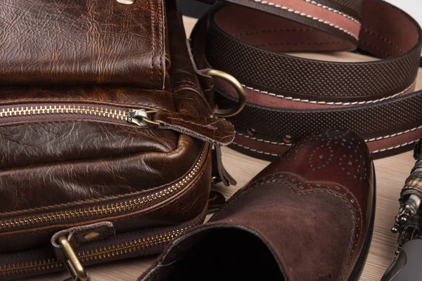 Chic classic brown shoes, belt, umbrella and briefcase on the wooden floor — Stock Photo, Image