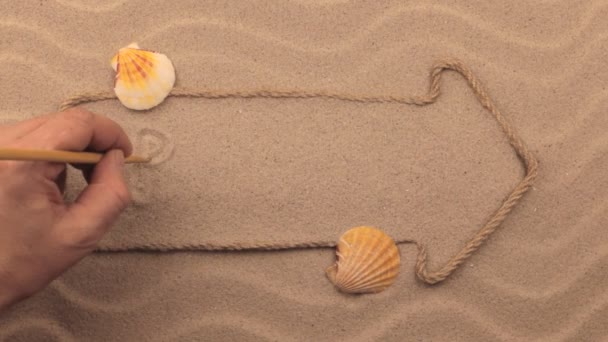 로프에서 만든 포인터에 모래에 손으로 쓰는 브라질 비문. — 비디오