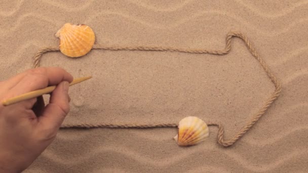 Ibiza inscription written by hand on the sand, in the pointer made from rope. — Stock Video