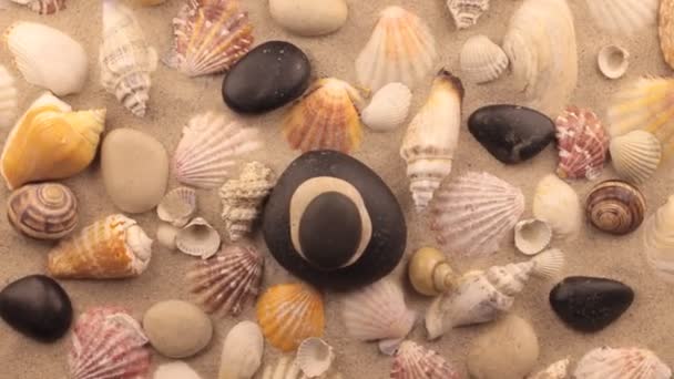 Rotación de la pirámide hecha de piedras de pie sobre la arena con conchas marinas . — Vídeos de Stock