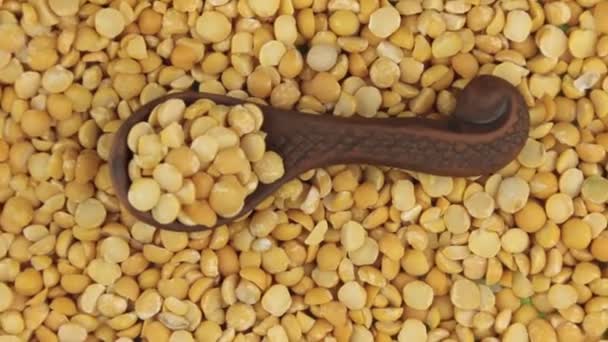 旋转和缩放的躺在豌豆种子的背景上粘土汤匙里的豌豆. — 图库视频影像