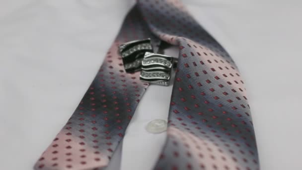 Dolly shot. Close-up knotted pink tie and cufflinks on a white shirt. — Stock Video