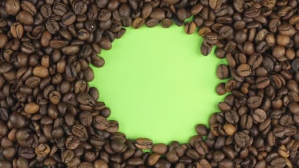 Rotation of the coffee beans lying on a green screen, chroma key. — Stock Video