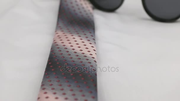 Red tie and sunglasses on a white shirt, close-up. Dolly shot. — Stock Video