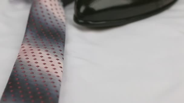 Video of red tie, mens shoes on a white shirt. Dolly shot. Close-up. — Stock Video
