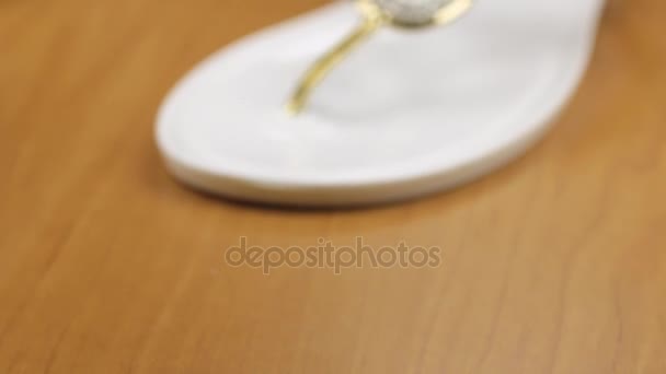 Video of white flip flops decorated with rhinestones. Dolly shot. Close-up. — Stock Video