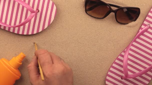 Panamaische Inschrift, handgeschrieben im Sand, inmitten von Strandaccessoires. — Stockvideo