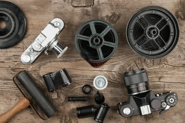 Oude camera's en accessoires liggen op de oude houten oppervlak. Nostalgische achtergrond. — Stockfoto