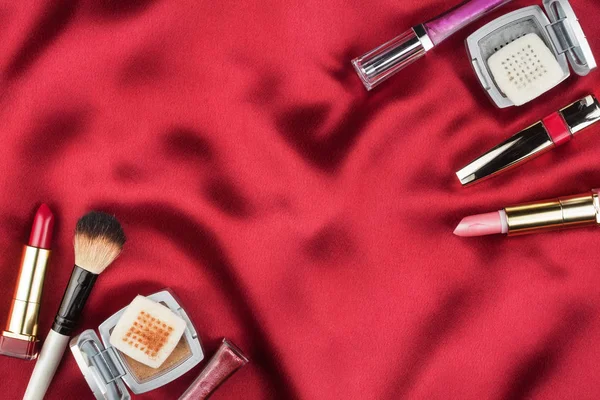 Trucco donna sdraiato su seta rossa, con spazio per il testo . — Foto Stock