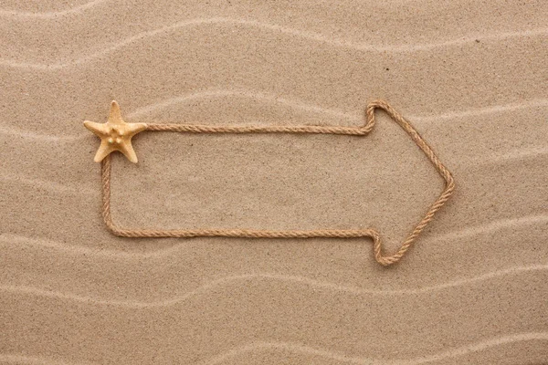 Ponteiro feito de corda e estrela do mar na areia, com lugar para o seu texto . — Fotografia de Stock