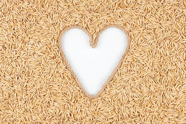 Oat grains and a rope in the shape of a heart with a place for designers. Stock Image