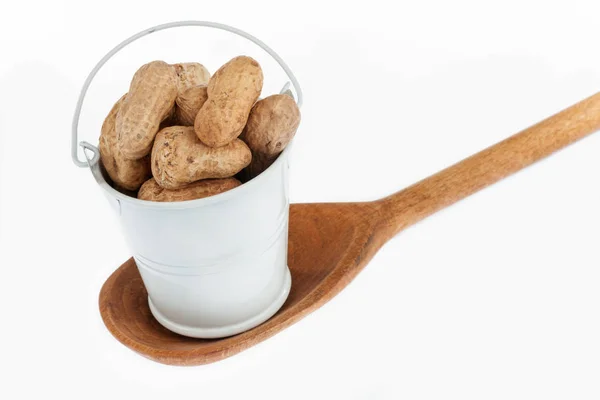 Full bucket of peanut stands in a wooden spoon. — Stock Photo, Image