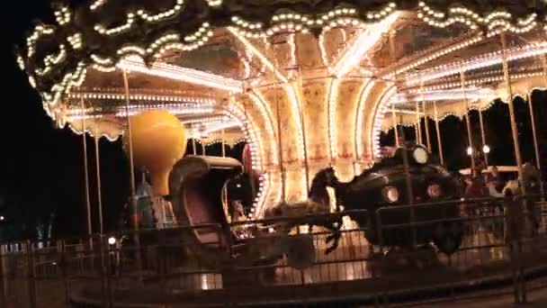 Belo carrossel clássico tudo nas luzes, girando em um parque noturno . — Vídeo de Stock