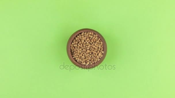 Zoom of a clay pot filled with buckwheat grain. Isolated green screen. — Stock Video