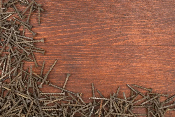 Marco de nuevos tornillos negros sobre una superficie de madera . —  Fotos de Stock