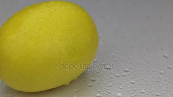 Vinden blåser bort dropparna vatten från en roterande citron. — Stockvideo