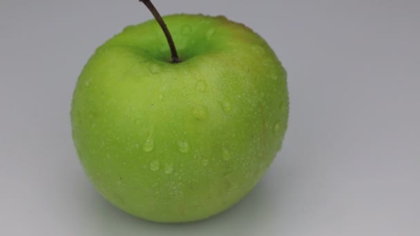 白色背景下的绿色苹果在露珠中的旋转. — 图库视频影像