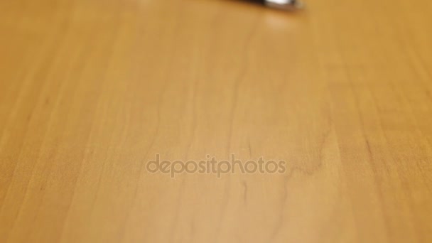 Dolly atirou. Close-up caneta esferográfica prata deitado sobre a mesa . — Vídeo de Stock