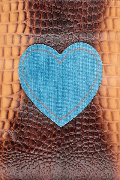 Heart made of denim lies on the crocodile skin. Space for text. — Stock Photo, Image