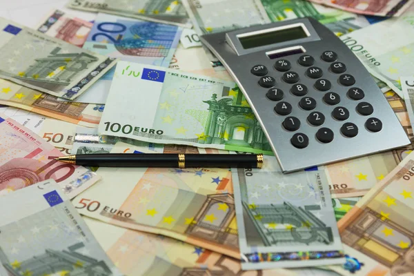 Calculator and money lie on the background of euros. Ideas and concepts of business. — Stock Photo, Image