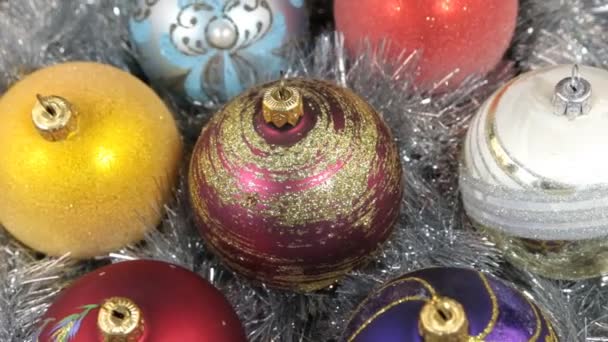 Primer plano de una rotación de bolas de Navidad multicolores. Fondo de Navidad, oropel . — Vídeo de stock