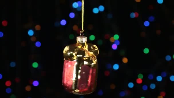 Zbliżenie, obrót czerwony świąteczny prezent powieszony na złote liny. Boże Narodzenie i nowy rok ozdoba. — Wideo stockowe