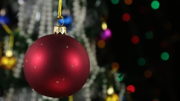 Vackra röda nyår och jul dekoration bollen kraftigt svängande på rep. — Stockvideo
