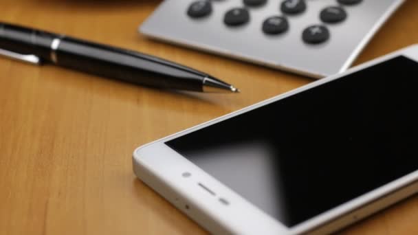 Poupée de mouvement du smartphone à une tasse de café debout sur la table . — Video