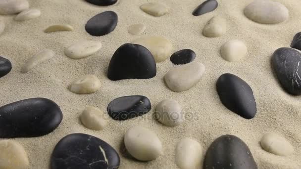Zoom o czarny kamień stojący na piasku wśród ogrodu kamieni. — Wideo stockowe