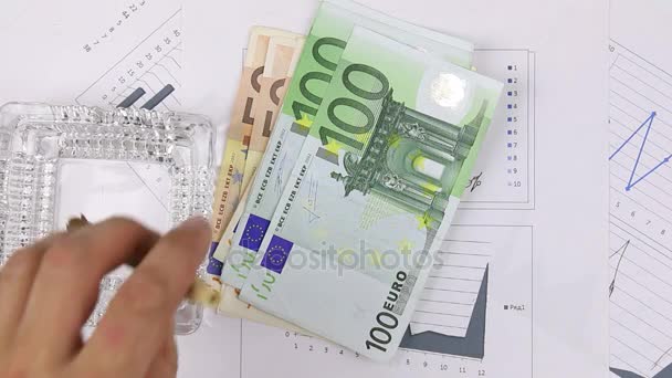 Copo de uísque e um dinheiro com charuto cubano e isqueiro em um diagrama. Close-up . — Vídeo de Stock