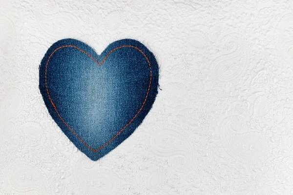 Classic heart made of denim lies on the embossed white skin. Space for text. — Stock Photo, Image