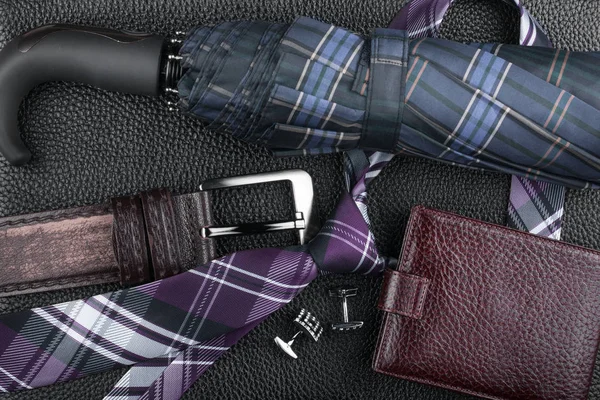 Klassieke luxe accessoires liggend op zwarte natuurlijk leder. — Stockfoto