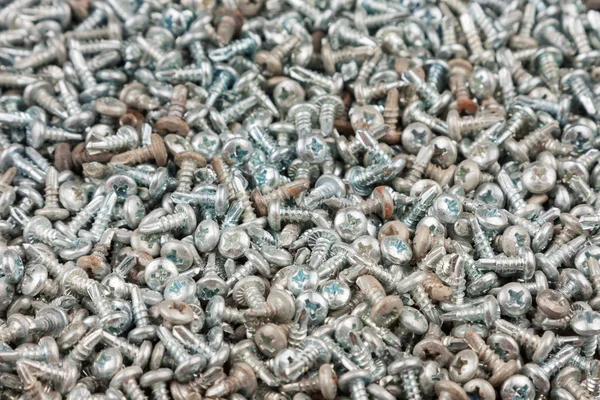 Background, texture of a pile of screws. Black screws abstract background. — Stock Photo, Image