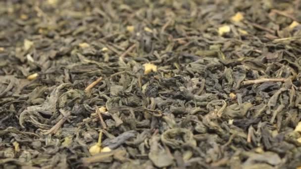 Obrót na tle zupełnie suchych liści zielonej herbaty. Szczelnie-do góry — Wideo stockowe