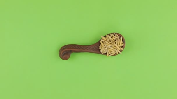 Rotation and approach of the spoon with oat grains, green screen. — Stock Video