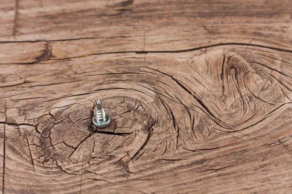 One screw with a drill head, stand on an old wooden surface. — Stock Photo, Image