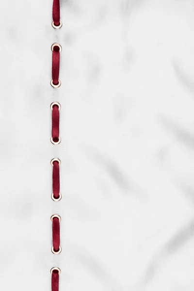 Ruban rouge inséré dans un satin ondulé blanc. Beau fond à la mode . — Photo