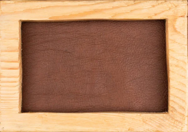 Rectangular frame made from light wood lies on brown natural leather. Texture of a tree. — Stock Photo, Image